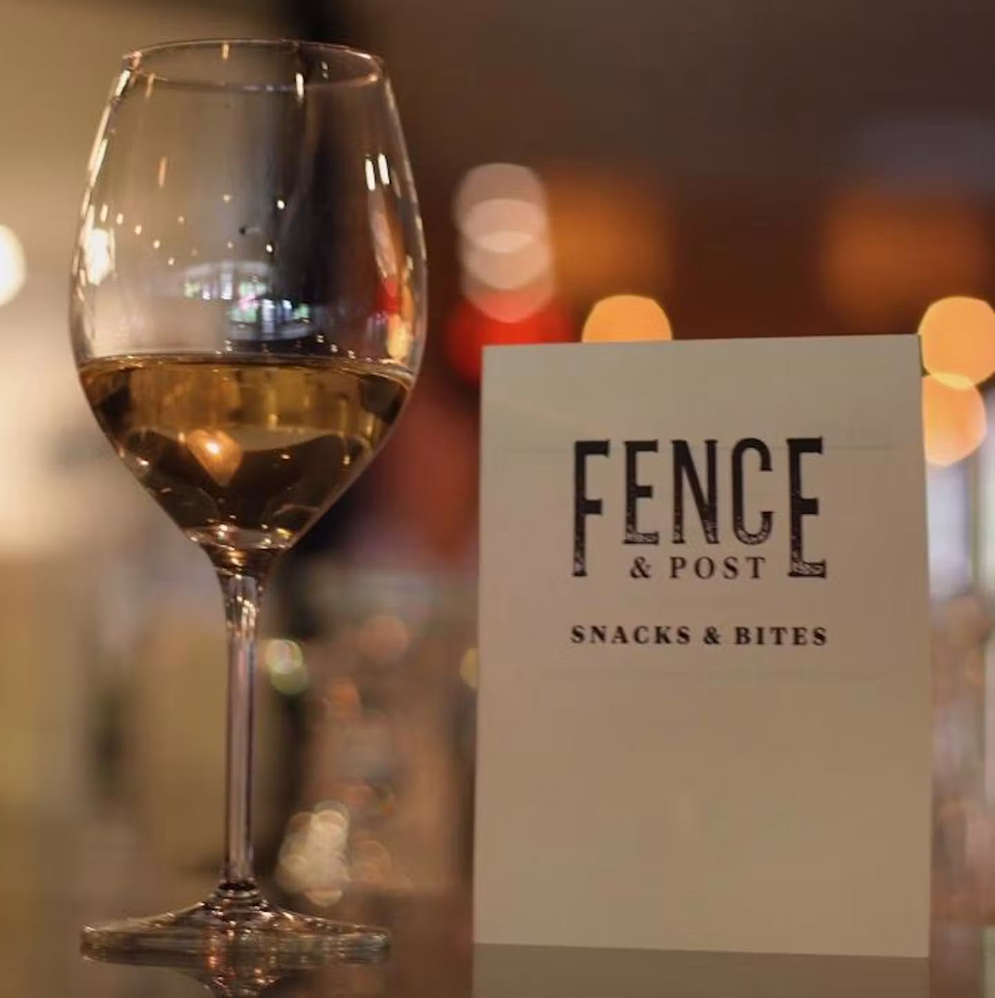 A glass of wine beside the Fence & Post menu